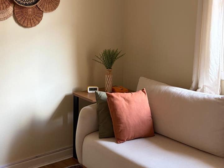 Sala de atendimento na Pompéia: sofá claro e painel de cestaria na parede